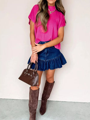 Relaxed mock neck knit top in bright pink with short sleeves and a ribbed texture.