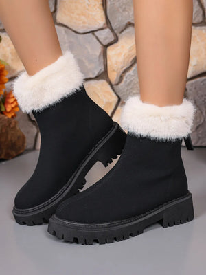 Black suede ankle boots with white faux fur trim and lug sole.