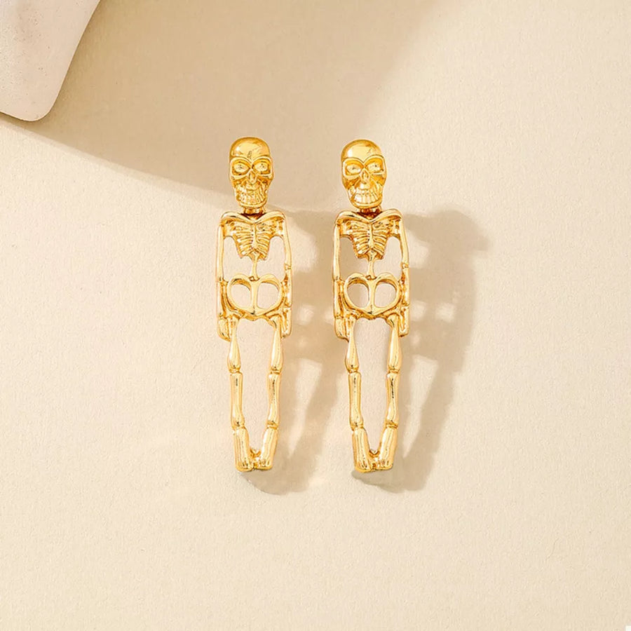 Gold earrings featuring dangle and skeleton