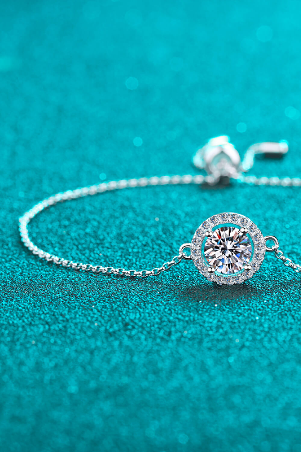 Silver adjustable bracelet with a round halo moissanite center stone.