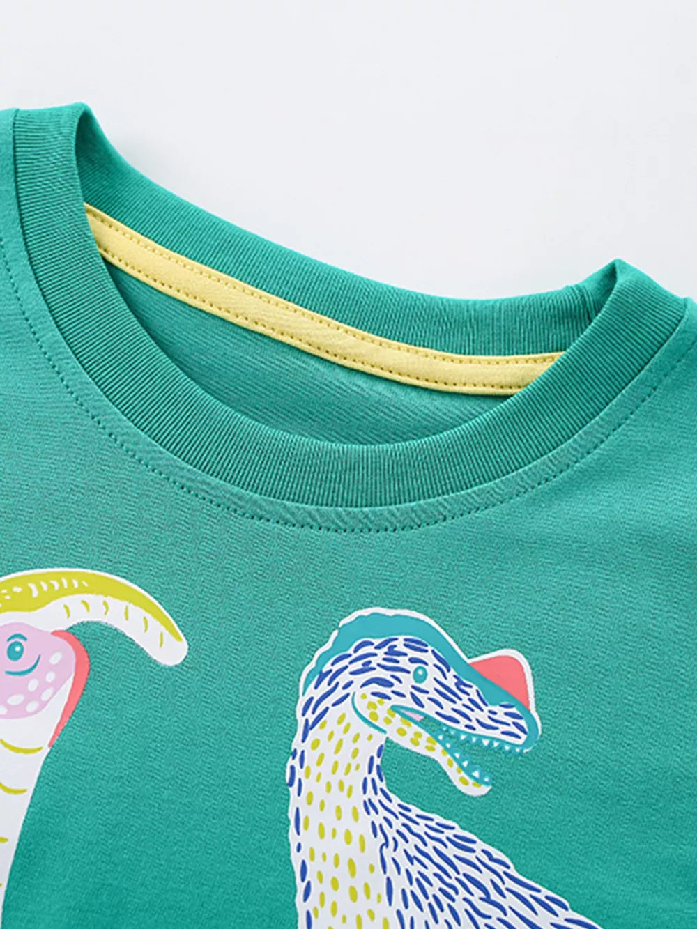 Green cotton crew neck t-shirt with colorful dinosaur print and yellow neck trim.