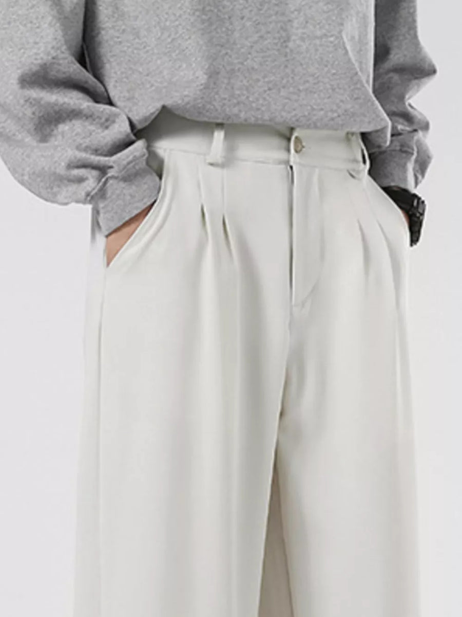 Men's cream pleated casual pants with a relaxed fit and side pockets.