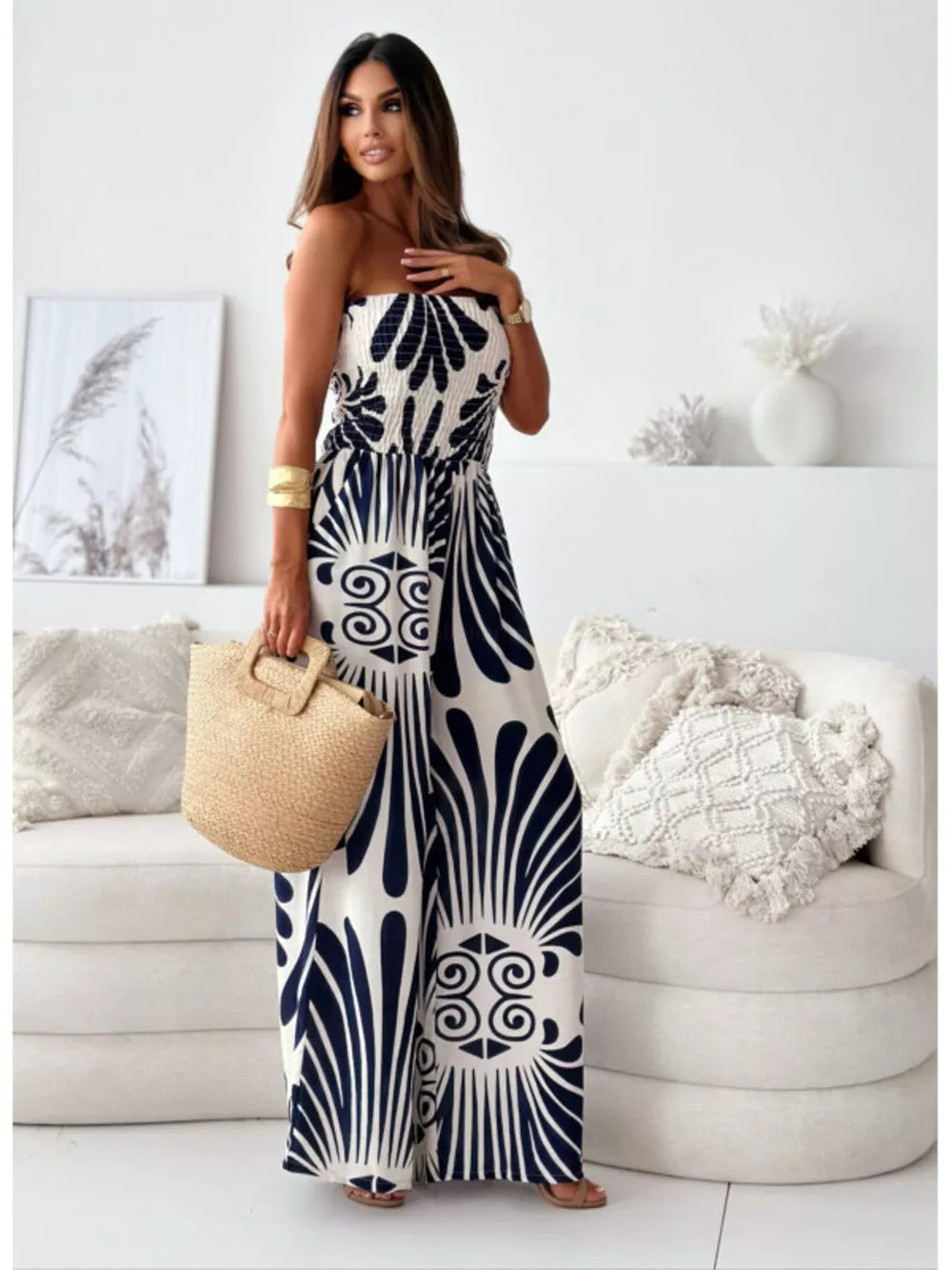 Strapless wide-leg romper in black and white tribal print polyester with smocked bodice.
