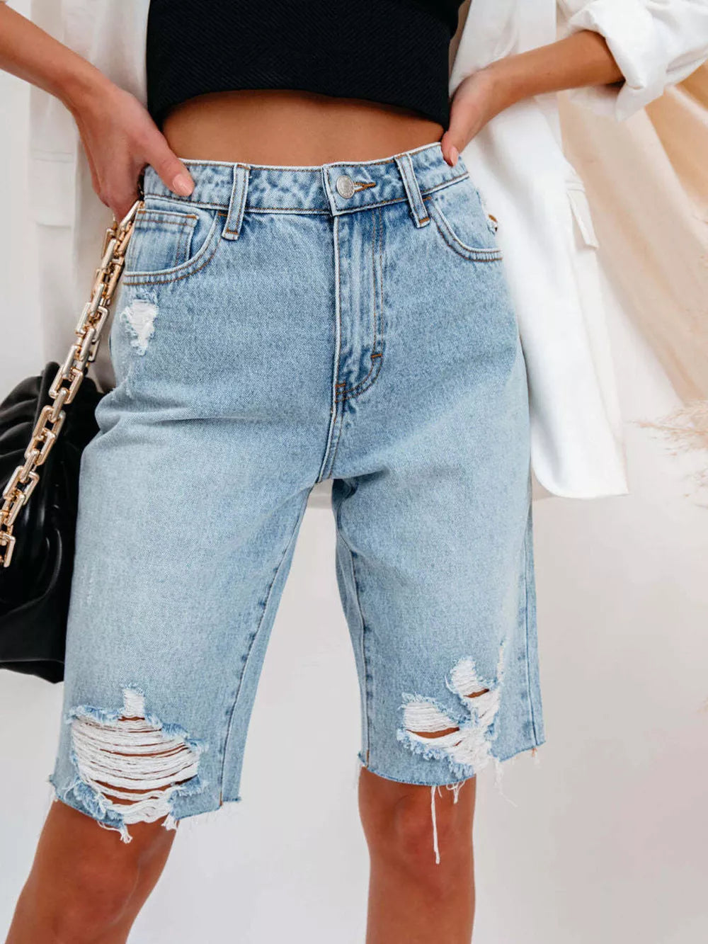 denim shorts in light blue featuring distressed and relaxed fit