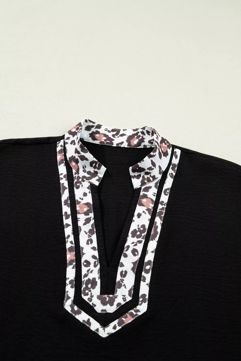 Black polyester tunic with leopard print notched neckline and trim