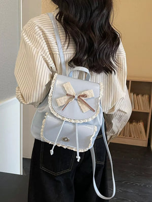 Blue mini backpack with lace trim and bow detail.
