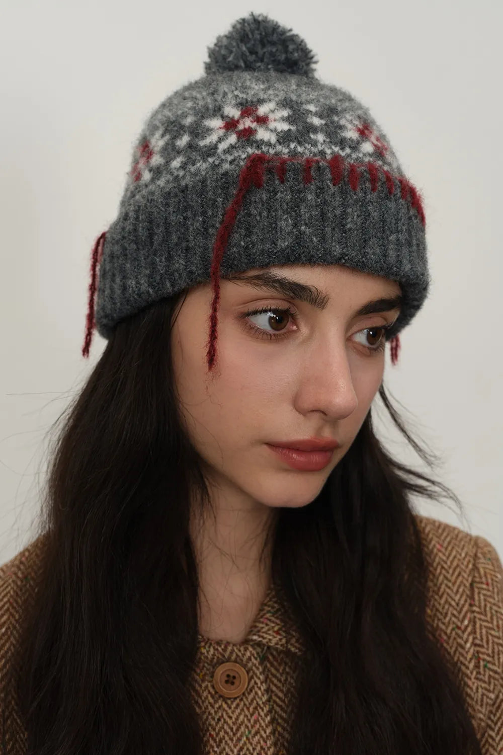 Dark gray Fair Isle beanie with pom-pom and red tassel detail