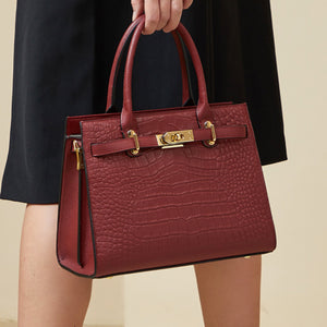 Burgundy crocodile-embossed medium tote handbag with gold hardware and top handles.