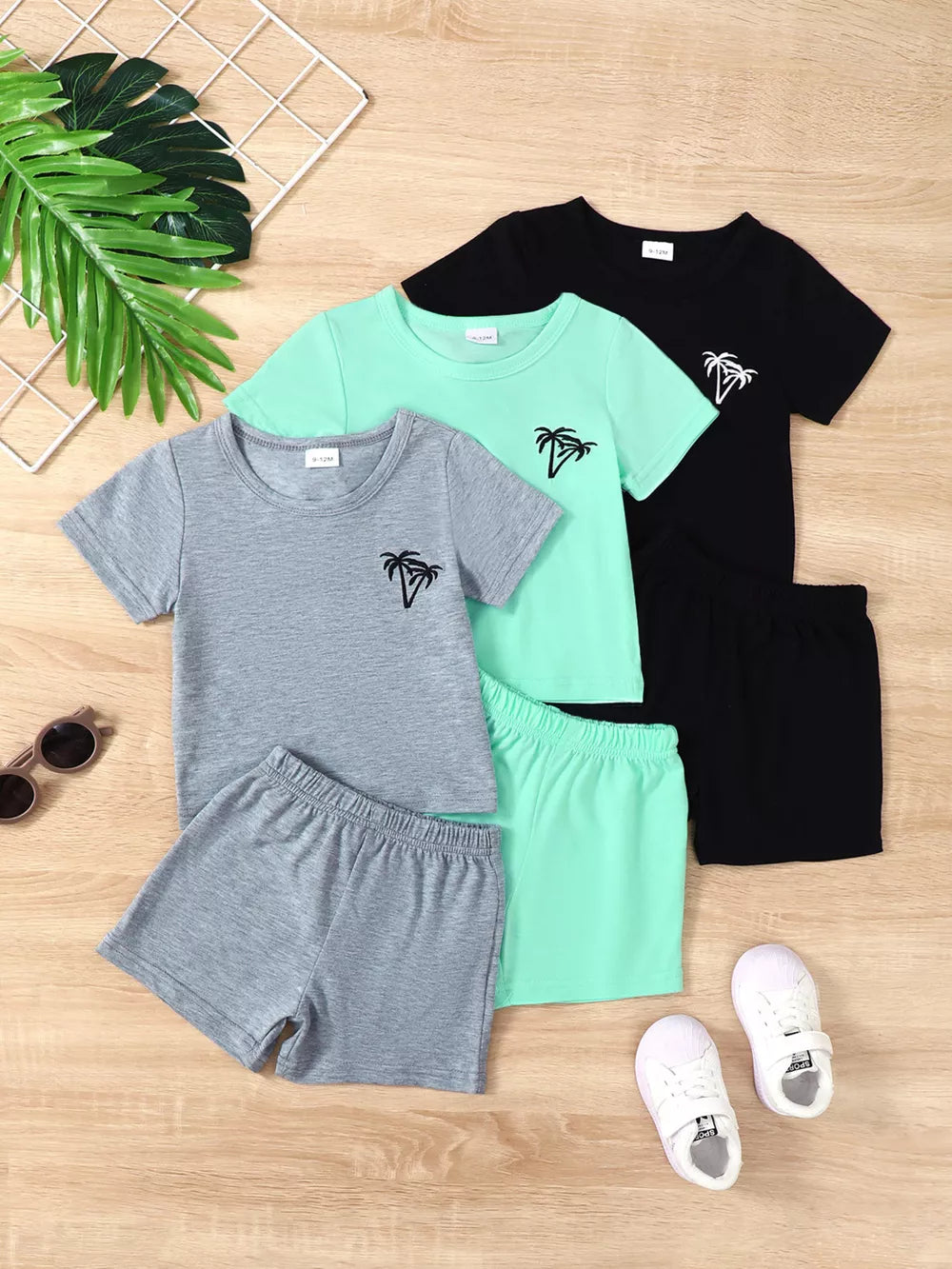 Boys' 4-piece tropical palm graphic baby set in grey, mint green, and black.