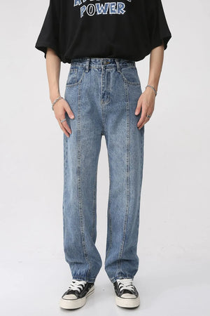 Medium wash denim jeans with vertical seam detail and relaxed fit.