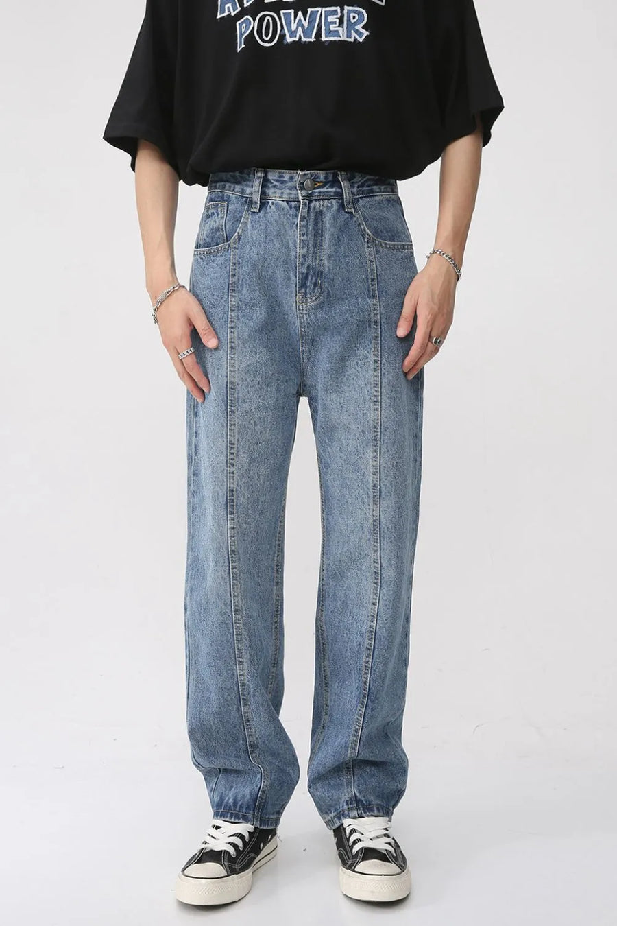 Medium wash denim jeans with vertical seam detail and relaxed fit.