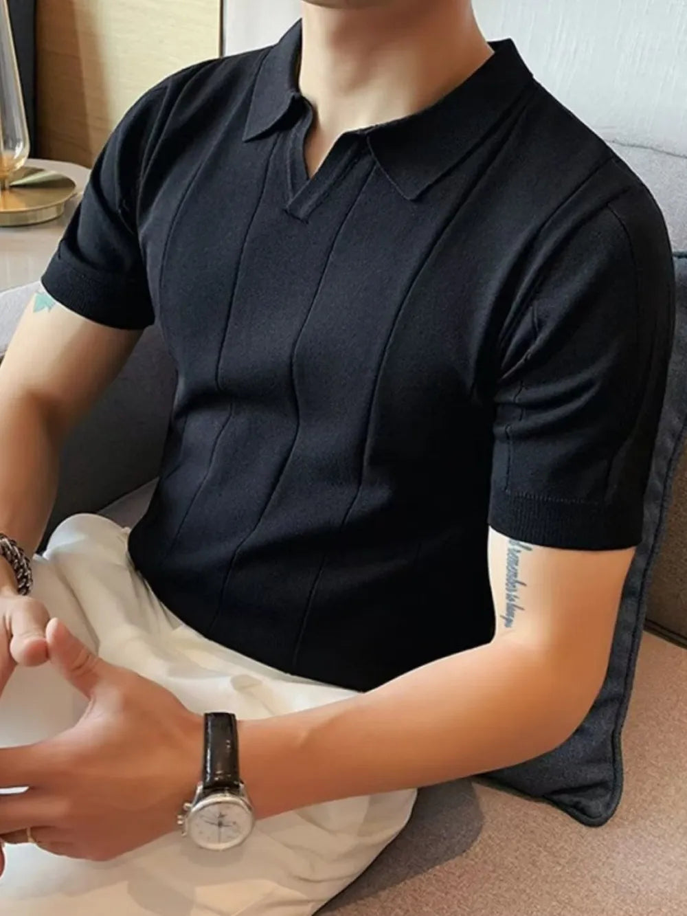 Black knit polo shirt with vertical ribbing and short sleeves