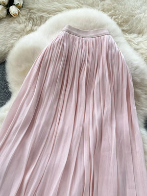 Pink pleated maxi skirt with a flowing A-line cut and elastic waistband.