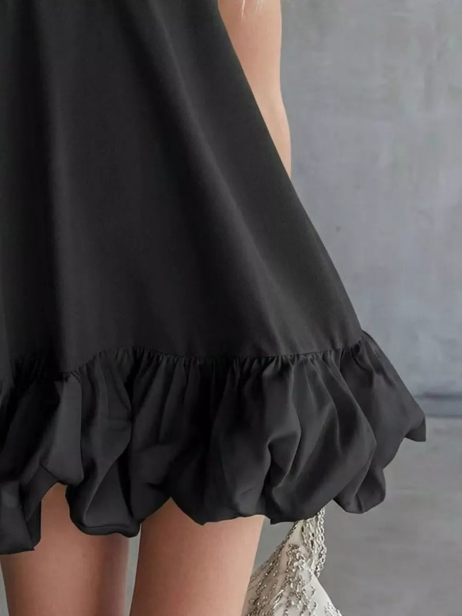 Black V-neck mini dress with bubble hem detail.