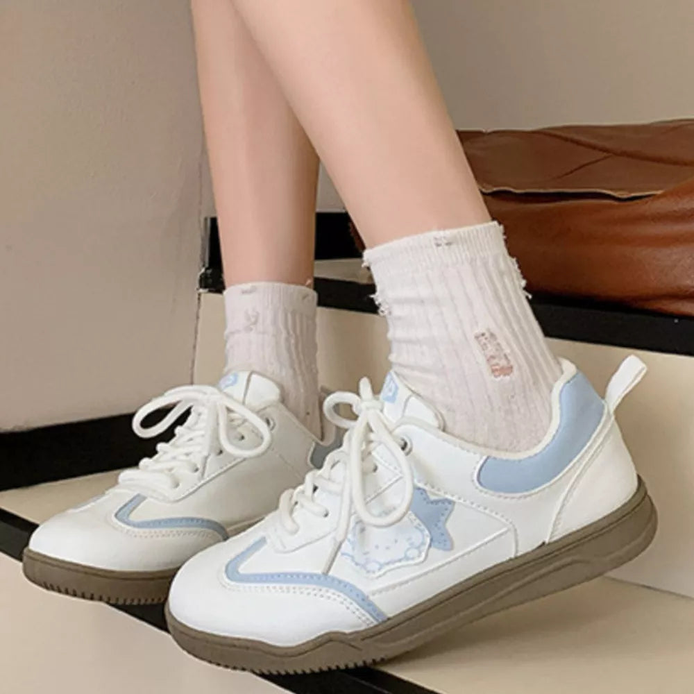 White lace-up sneakers with blue accents and a cartoon character detail.