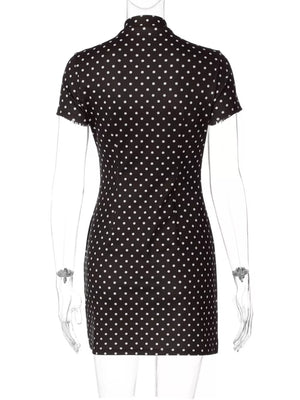 Black polka dot mini dress with short sleeves and a mock neck.