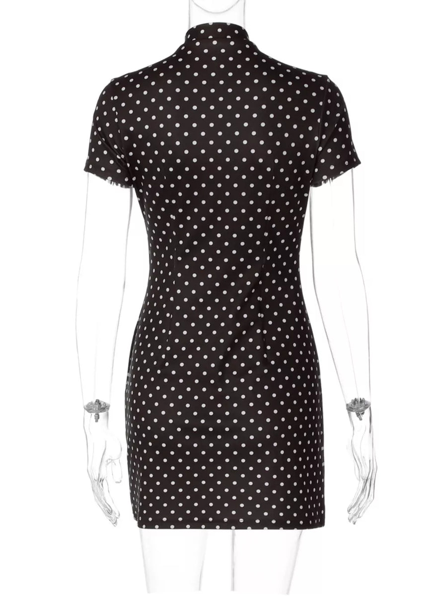 Black polka dot mini dress with short sleeves and a mock neck.