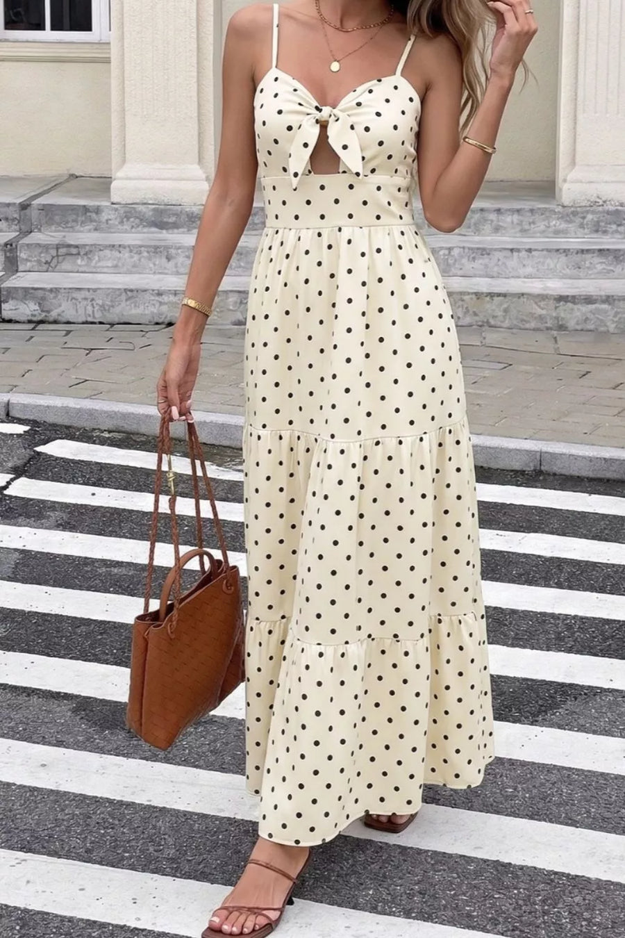 Cream polka dot maxi dress with tie-front cutout and tiered skirt.