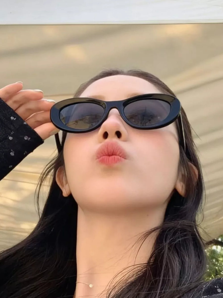 Black cat eye sunglasses with oval lenses and thick frames.