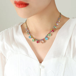 Rainbow gemstone cascade necklace with colorful dangling charms on a gold chain.