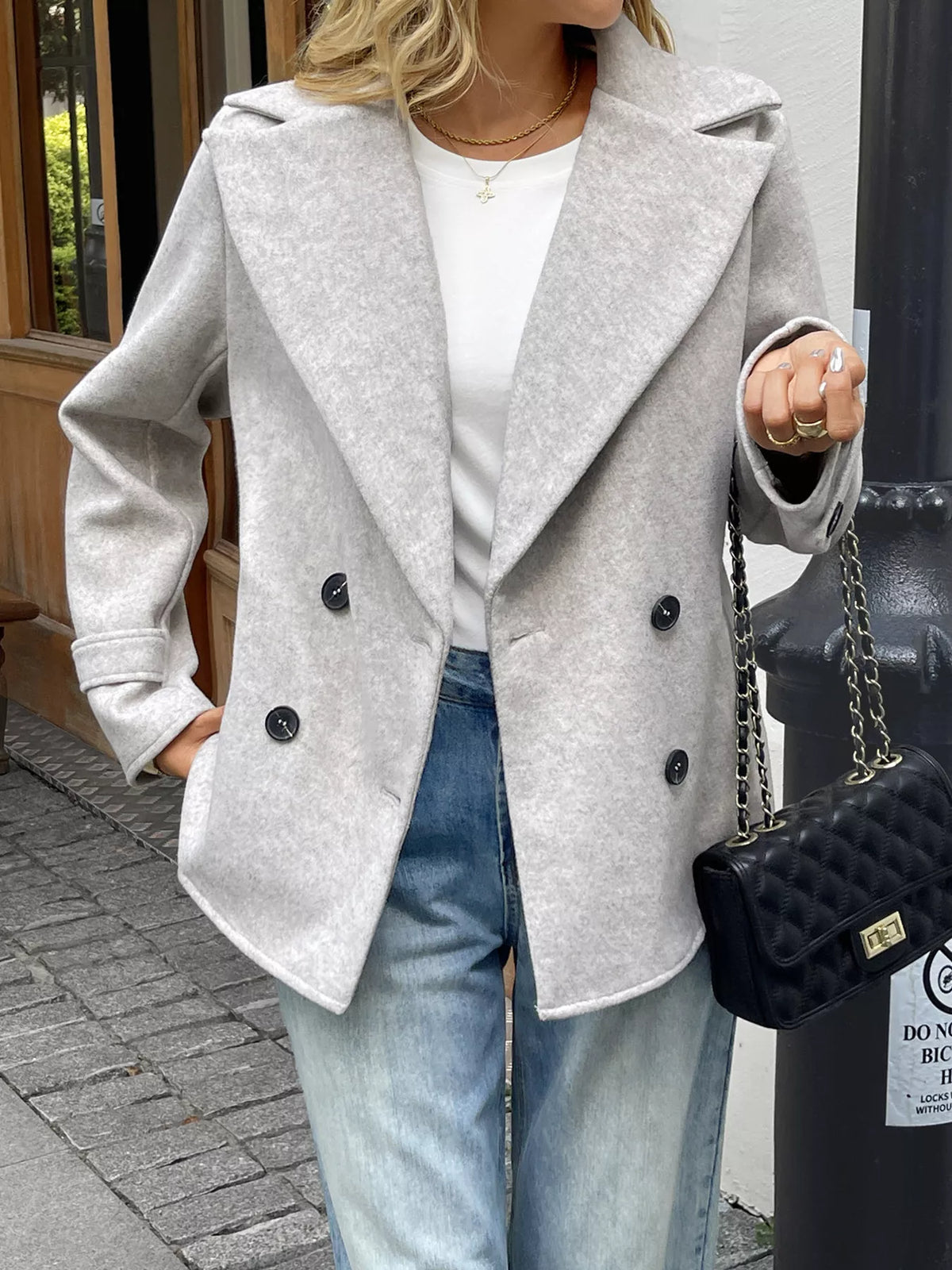 Light grey wool blend double-breasted jacket with wide lapels and button closure.