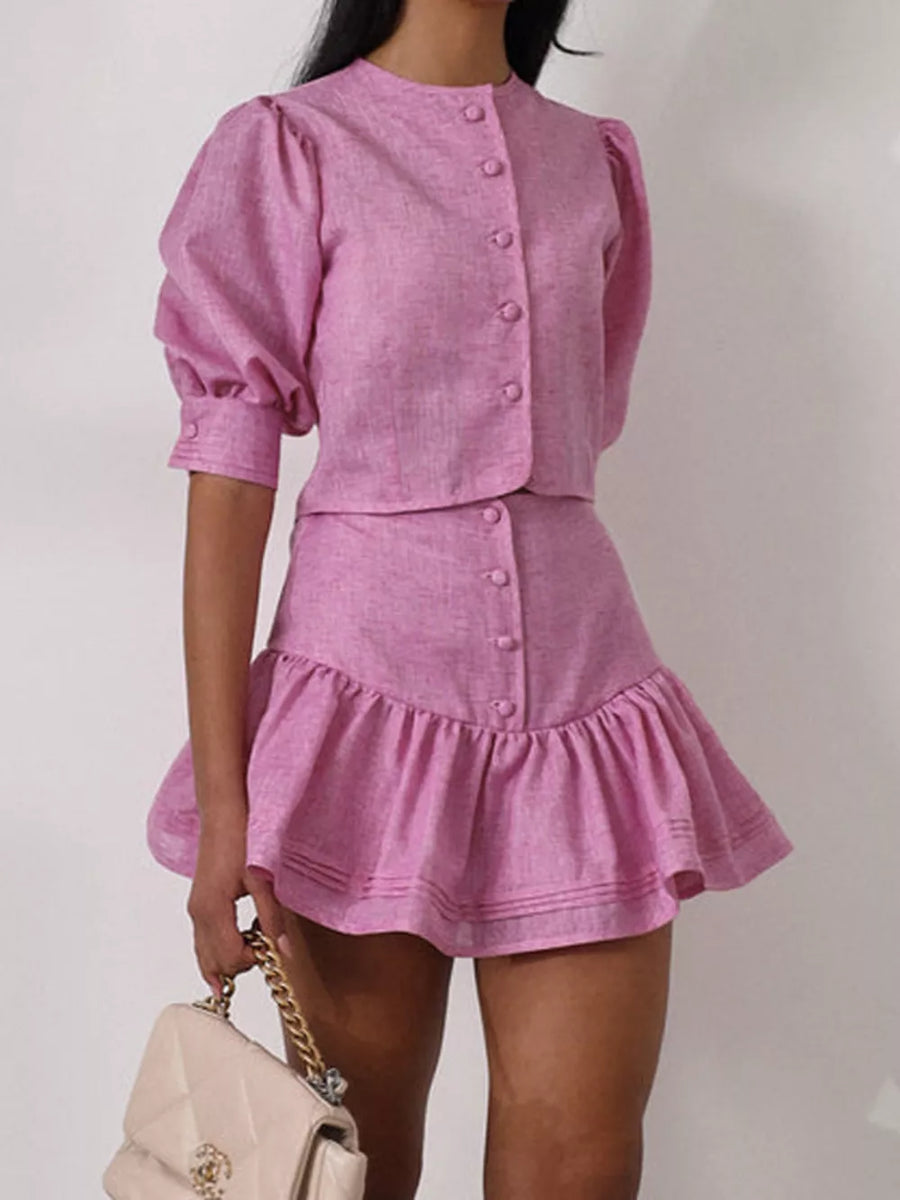 Pink linen puff sleeve crop top and ruffled mini skirt set with button details.