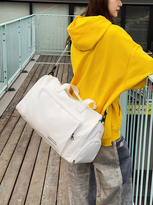 Spacious white canvas travel bag with zippered pockets and versatile straps.