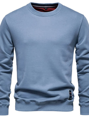 Light blue crewneck sweatshirt with subtle patch detail on hem