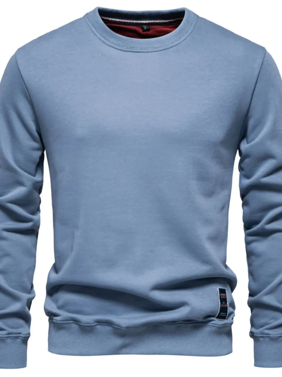 Light blue crewneck sweatshirt with subtle patch detail on hem