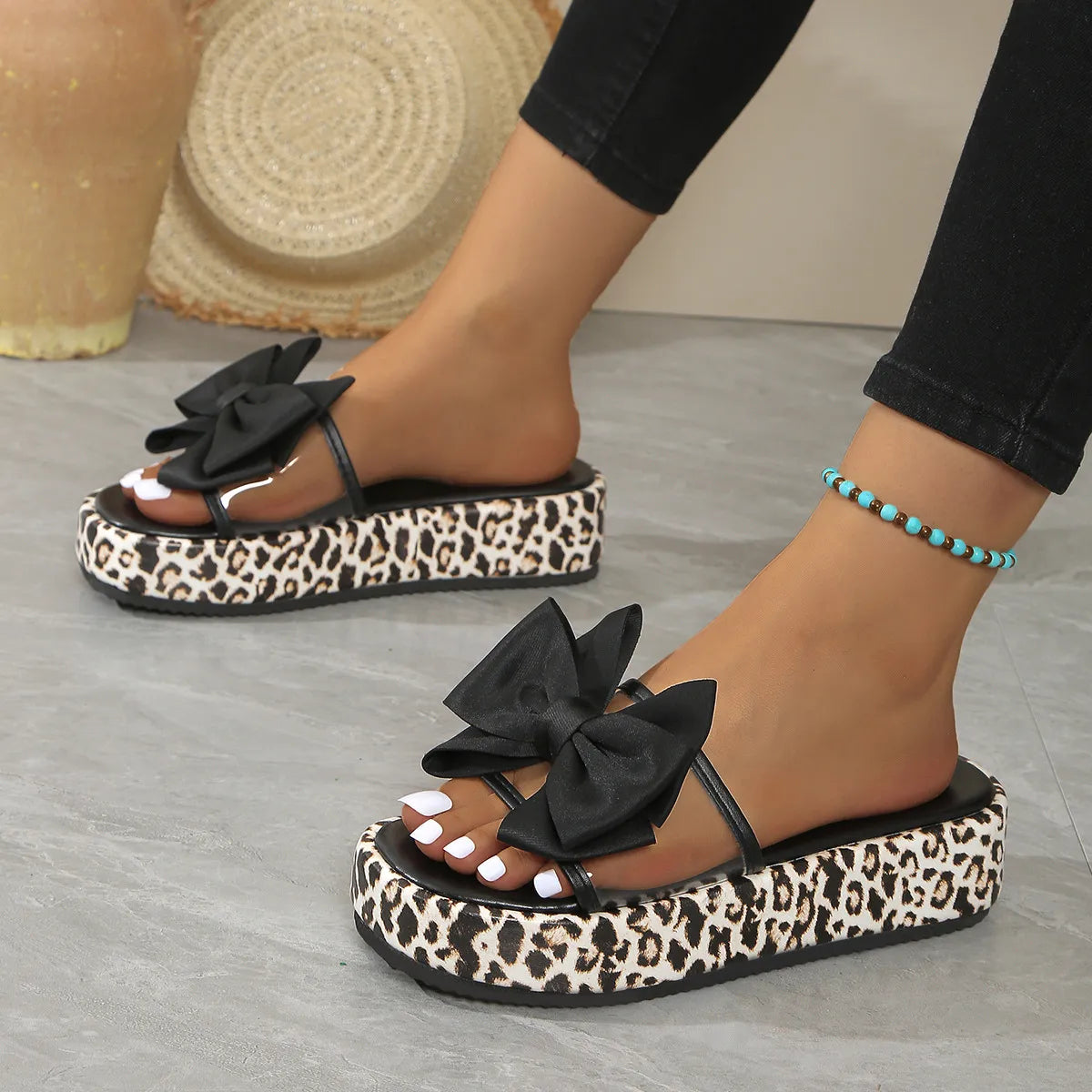 Leopard print platform slides with black bows and clear straps.