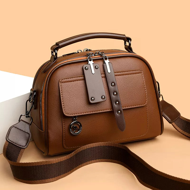 Brown leather crossbody bag with adjustable strap and front pocket detail
