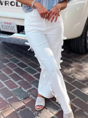 White cotton maternity trousers with side bow embellishments and wide legs.