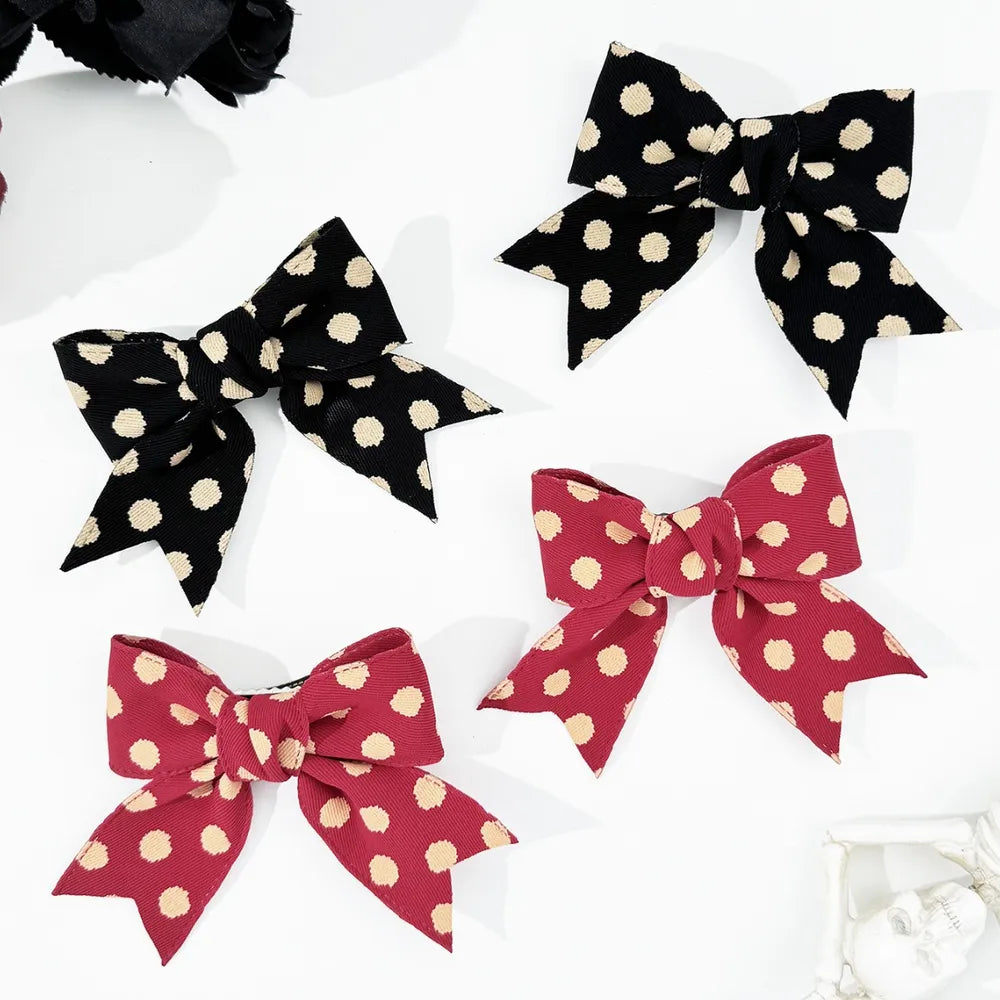 Polka dot bow barrettes set in black and deep red with cream polka dots.