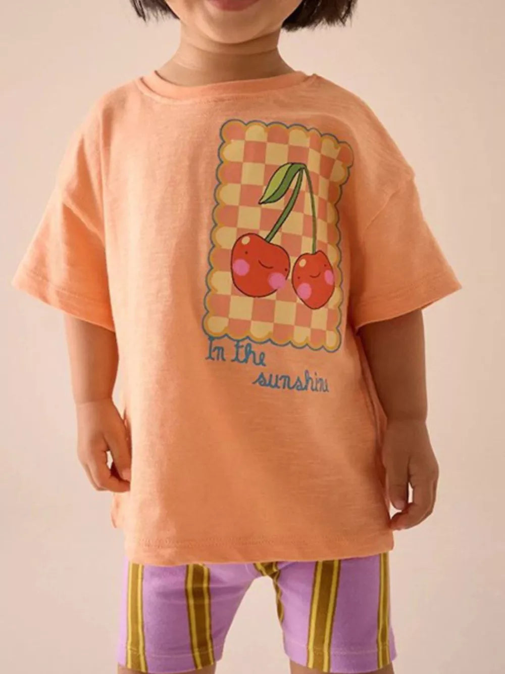 Toddler orange t-shirt with cheerful cherry graphic and "In the sunshine" text
