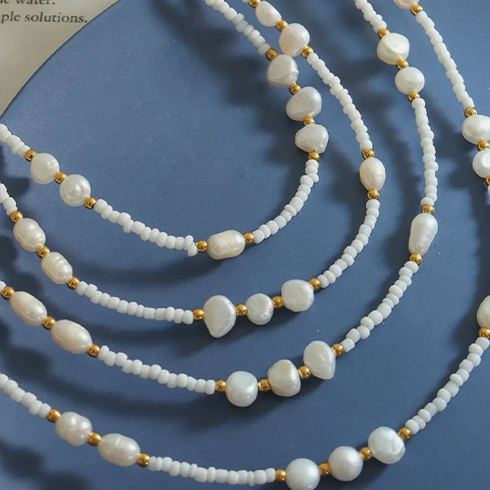 White seed bead strand necklace with baroque pearls and gold accents