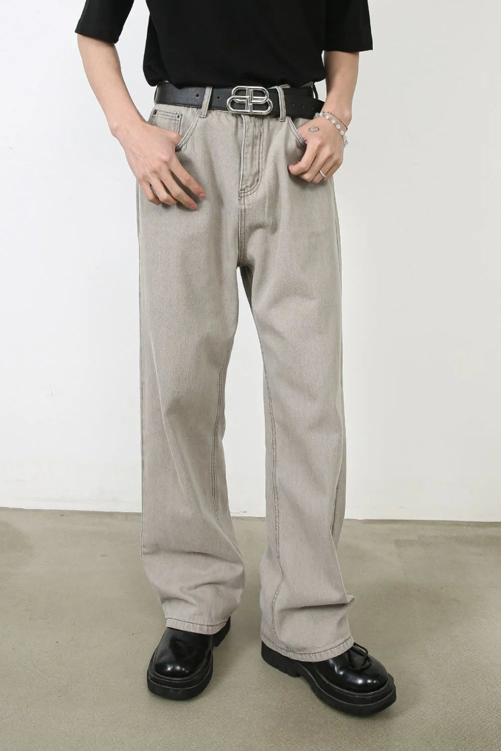 Gray wide-leg denim trousers with seam detail and a relaxed fit.