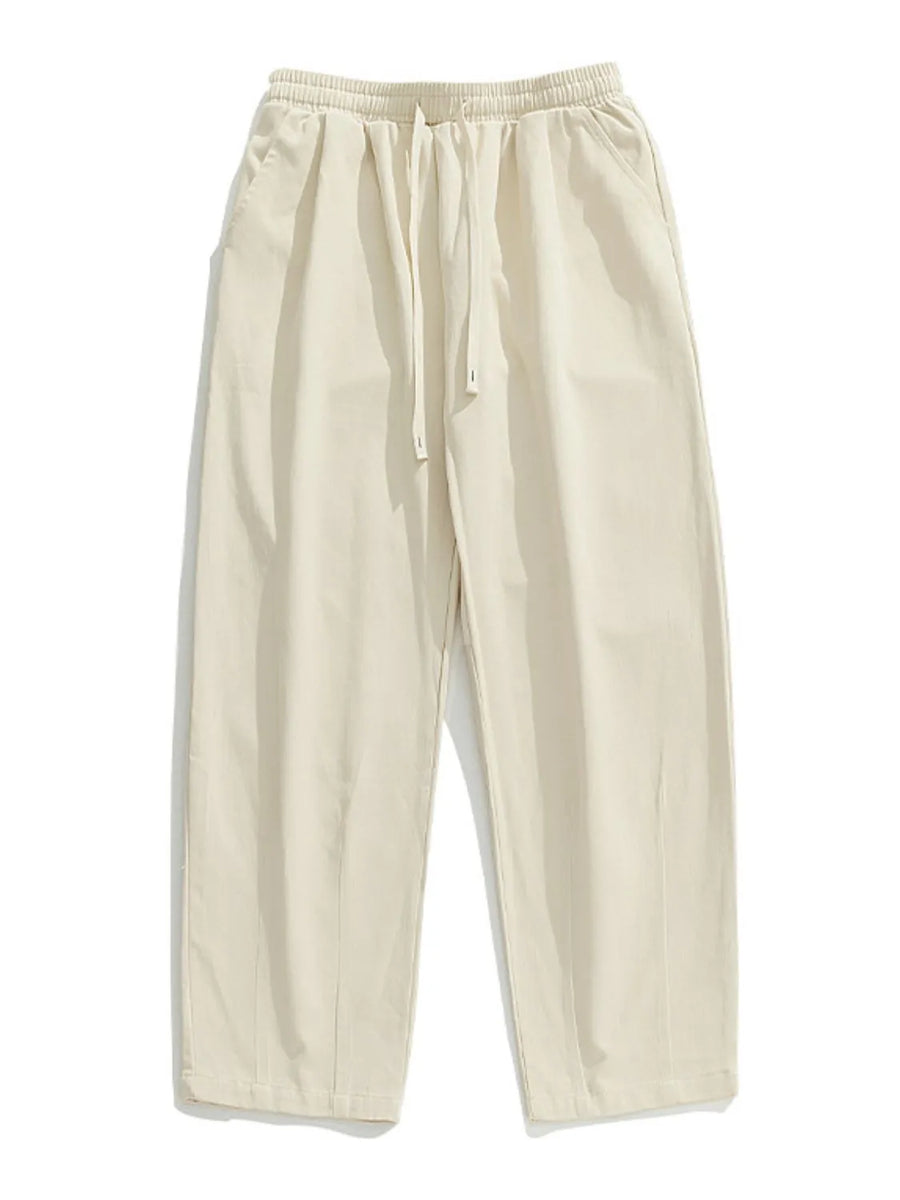 Ivory wide-leg pleated drawstring trousers with a relaxed fit and side pockets.