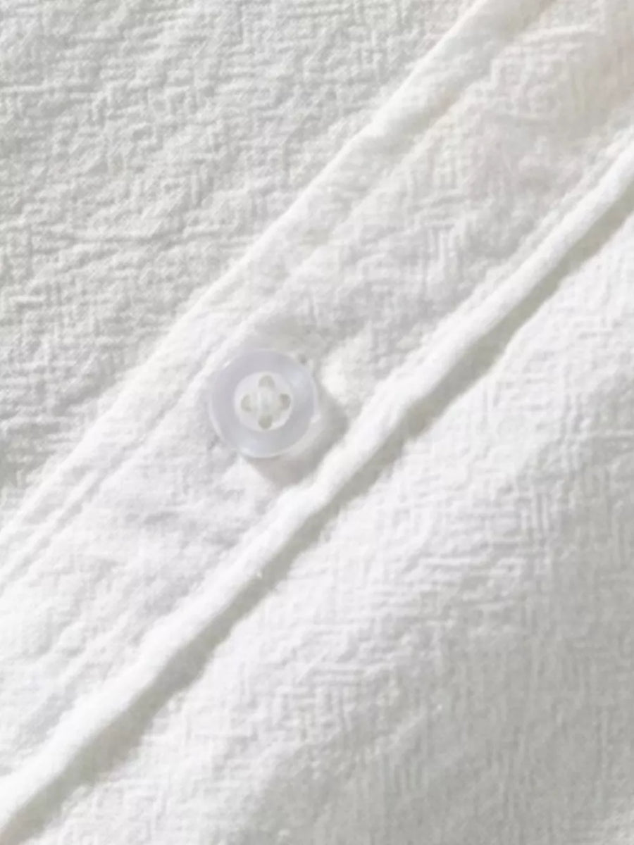 White men's button-up shirt with textured fabric and a single visible button.