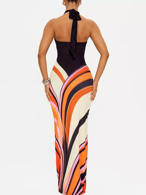 Maxi dress with halter neck and bold abstract stripe print in black, cream, orange, and pink.