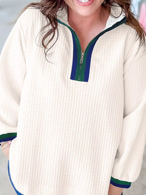 Textured white half-zip sweatshirt with blue and green stripe collar detail.