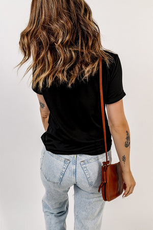 Black t-shirt with rolled sleeves and a crew neck, styled with light wash jeans and a brown crossbody bag.