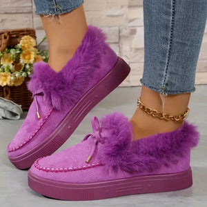 Purple suede loafers with shearling trim and bow detail.