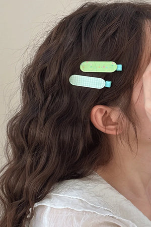 Pastel blue gingham and green patterned hair clips with blue accents.