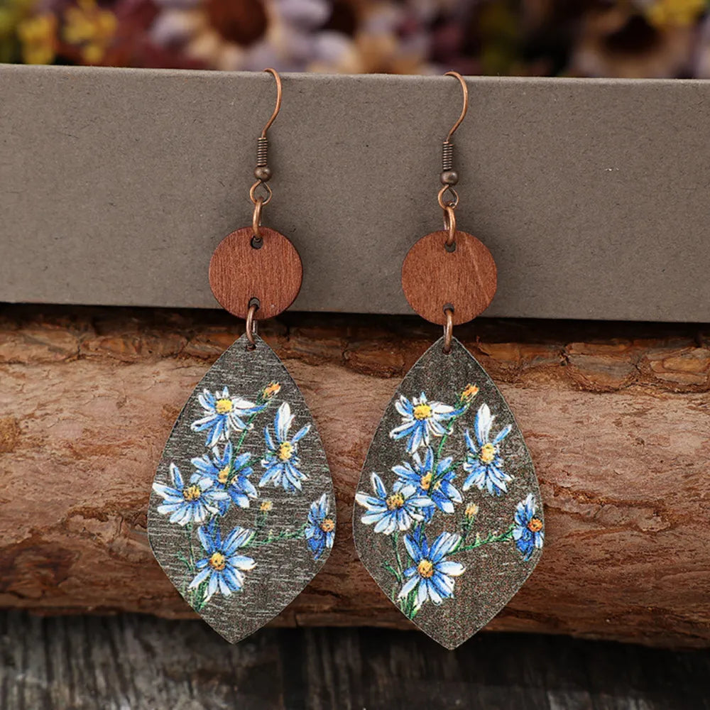 Botanical wood teardrop earrings in light blue with floral print and copper hooks.