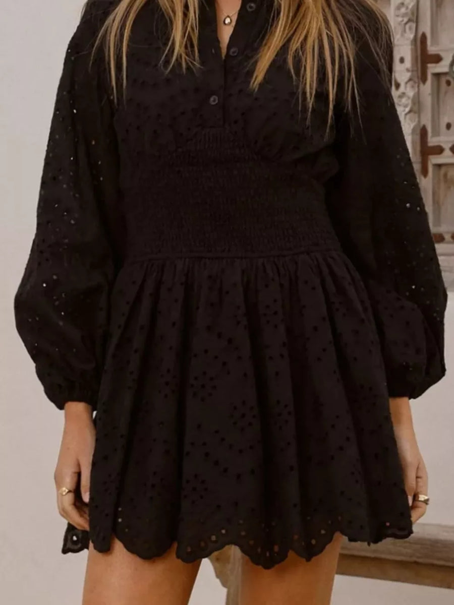 Black eyelet mini dress with smocked waist and balloon sleeves.