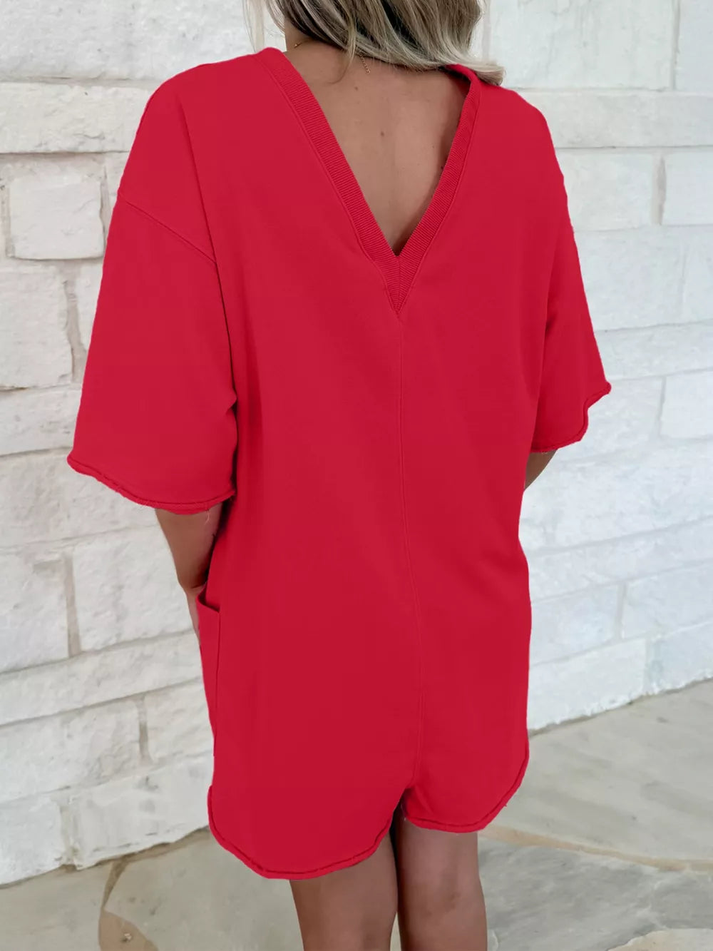 Scarlet cotton romper with V-neck, half sleeves, and pockets.