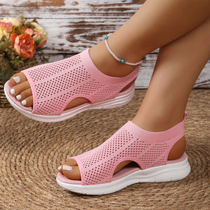 Pink mesh open-toe sandals with a chunky white sole and breathable knit upper.