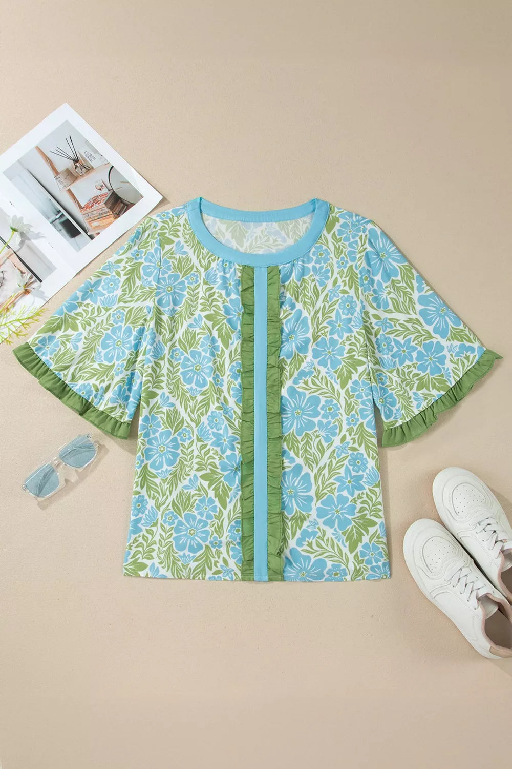 Floral ruffled half sleeve maternity blouse with blue and green floral print and front ruffle detail.
