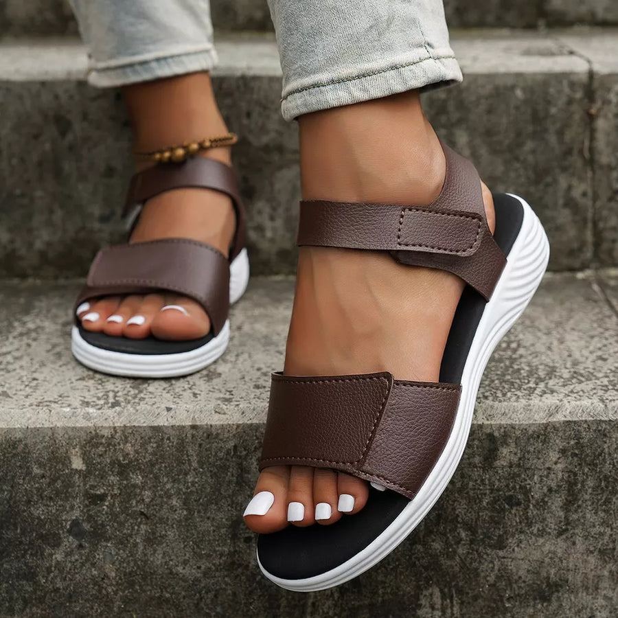 Brown adjustable open-toe platform sandals with chunky white soles.