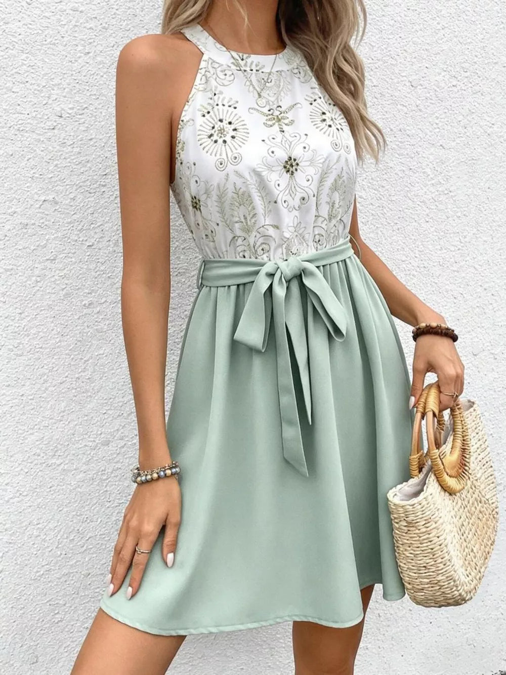 Floral print a-line dress with tie waist and sage green skirt.